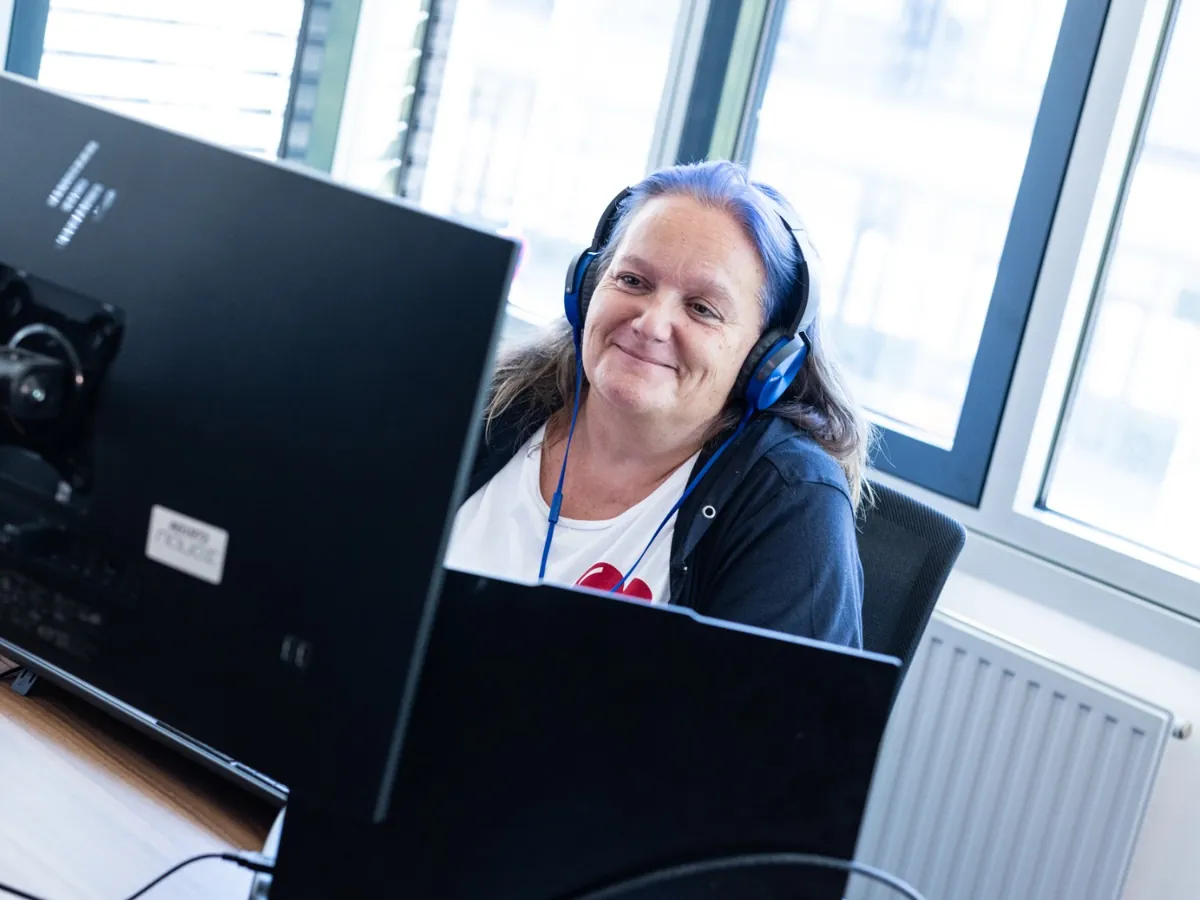 Employee with a headset at two screens
