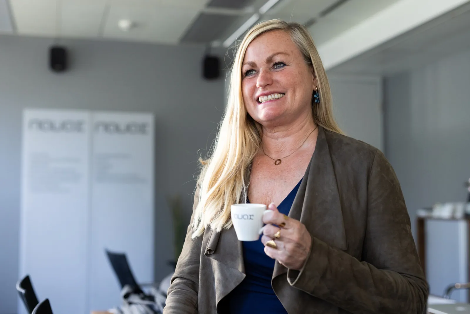 Mitarbeiterin mit Kaffeetasse in einem hellen Büro
