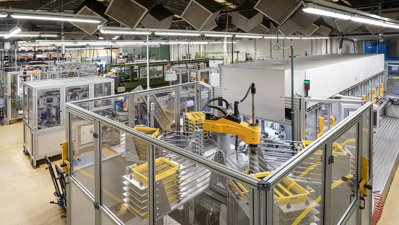 EVVA production hall with a robot cell and yellow workpiece carriers