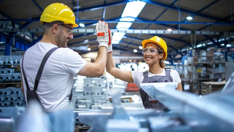 Employees in a production plant clap a