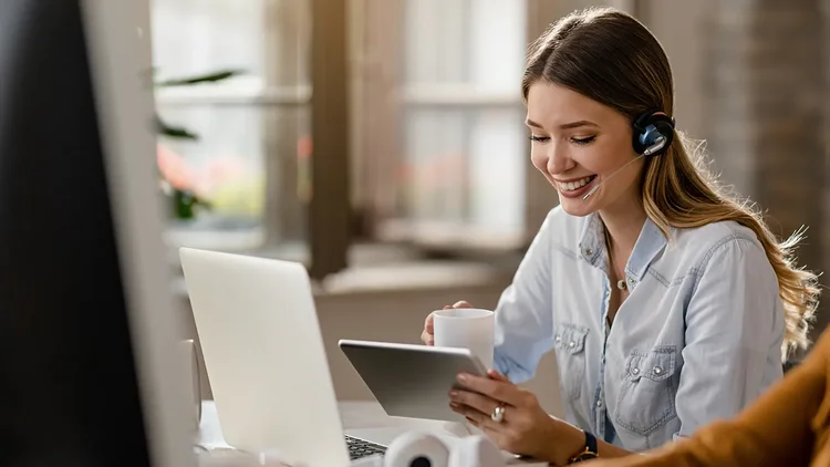 Frau im Kundenservice telefoniert mit Kunden und hat CRM Lösung offen