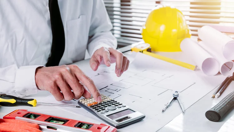 Bauleiter fĂŒhrt gerade die Teilkostenrechnung der Baustelle durch