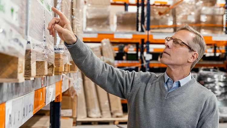Mann begutachtet die Artikel im Lager eines Großhandels