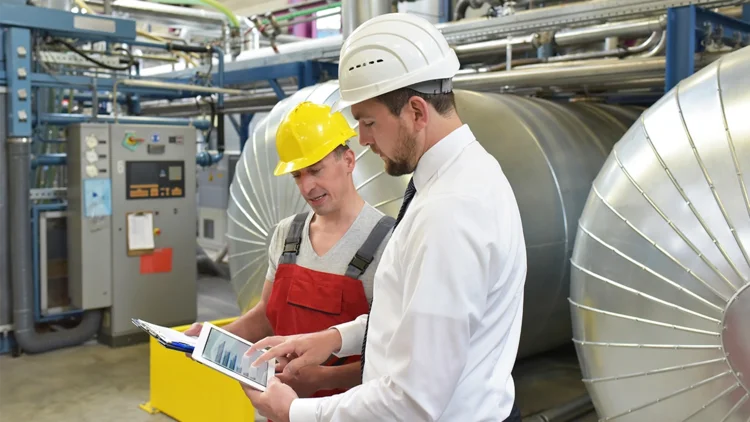 Employees in manufacturing consult each other in production