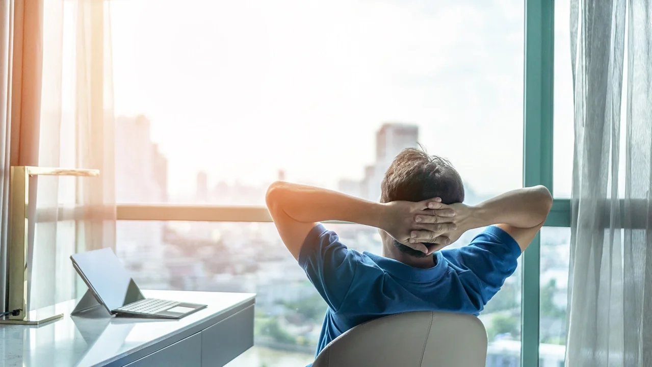 Mann schaut entspannt aus dem Fenster