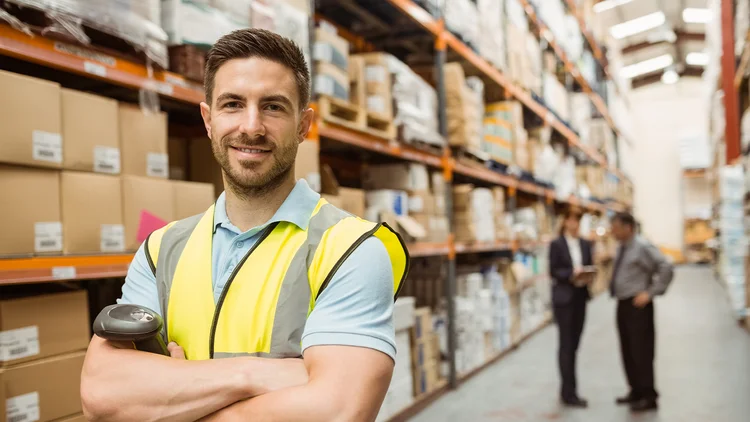 Lagermitarbeiter lächelt während er Artikel kommissioniert
