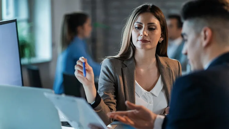 Frau erklÀrt Mann etwas auf einem Bildschirm und zeigt Marketing Automation