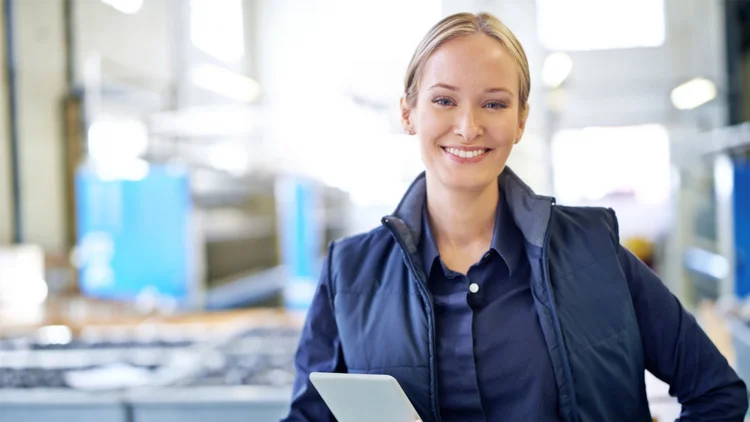 An employee in Manufacturing checks the machine orders