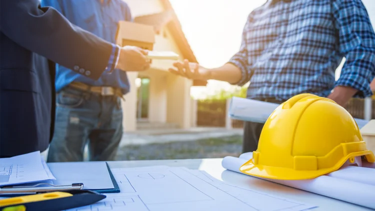 MĂ€nner geben sich die HĂ€nde auf Baustelle